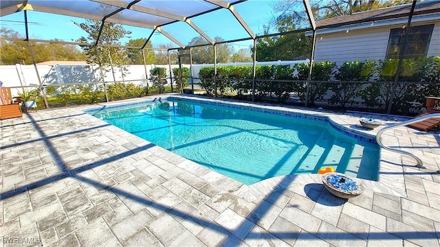 view of swimming pool with a patio area, fence, a fenced in pool, and a lanai