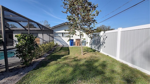 view of yard with fence, a fenced in pool, and a lanai