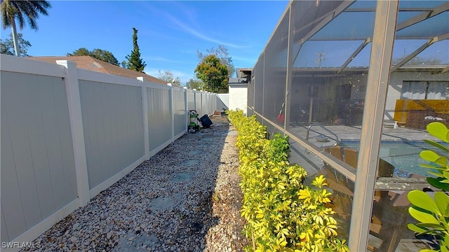 view of yard with a lanai, a patio area, a fenced backyard, and a fenced in pool