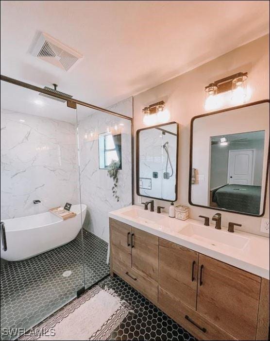 full bath with a freestanding bath, double vanity, a stall shower, and a sink