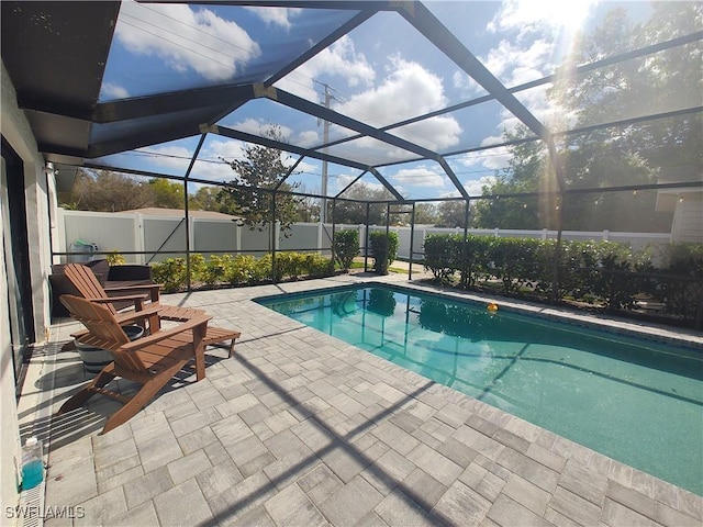 view of pool featuring a fenced in pool, glass enclosure, a patio area, and a fenced backyard