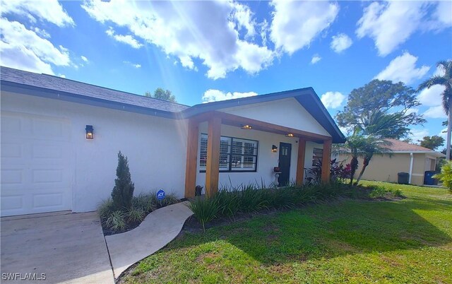 ranch-style house with an attached garage, a front yard, and stucco siding