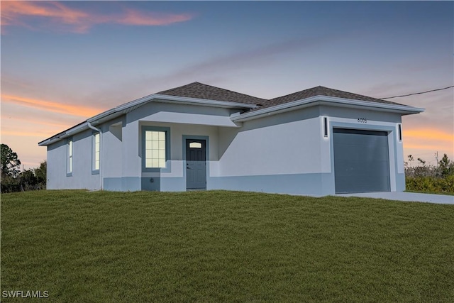 view of front facade with a garage and a lawn