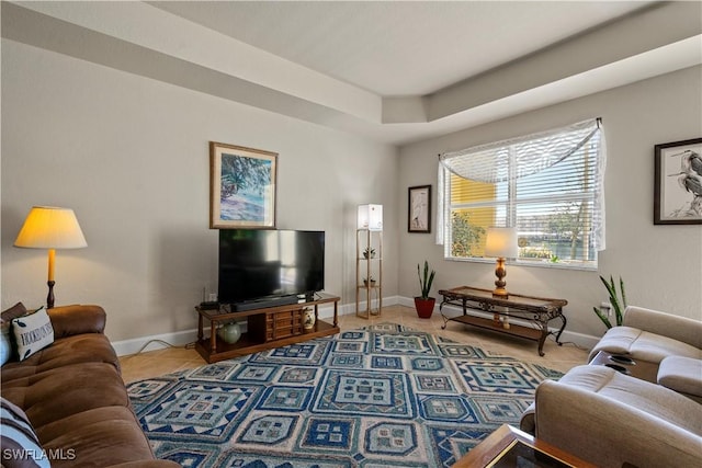 living room featuring a tray ceiling and tile patterned flooring