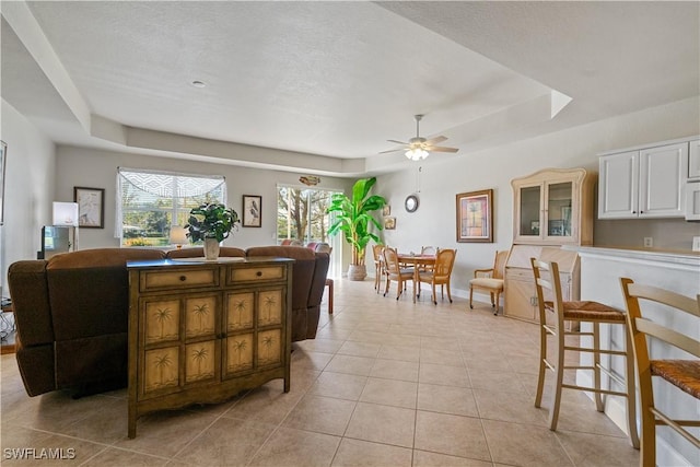 interior space with a raised ceiling and ceiling fan