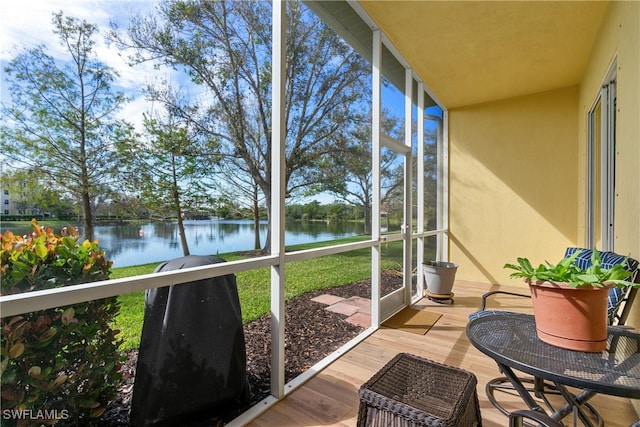 sunroom featuring a water view