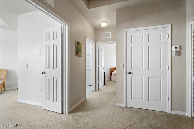 hall with light colored carpet