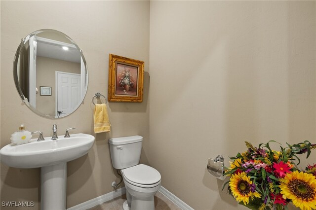 bathroom featuring toilet and baseboards