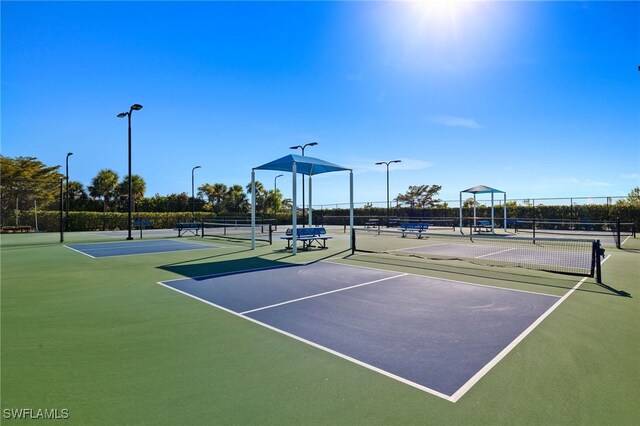 view of tennis court with fence and community basketball court