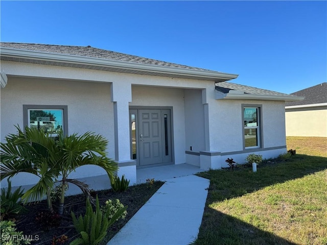 entrance to property featuring a yard