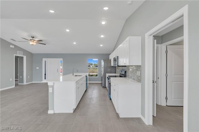 kitchen with lofted ceiling, sink, a kitchen island with sink, white cabinetry, and stainless steel appliances