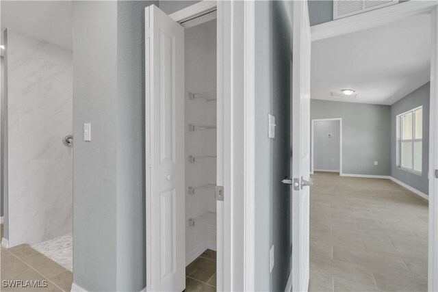 bathroom with tile patterned flooring and tiled shower