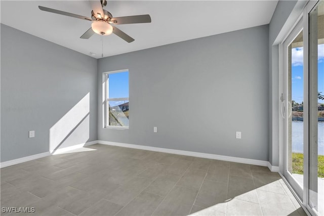 unfurnished room featuring a water view and ceiling fan