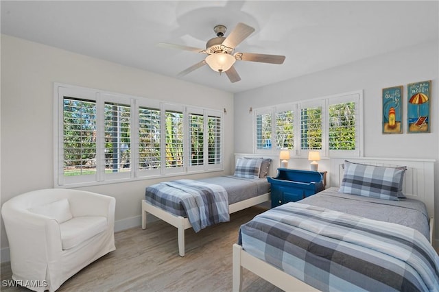 bedroom featuring ceiling fan, baseboards, and wood finished floors