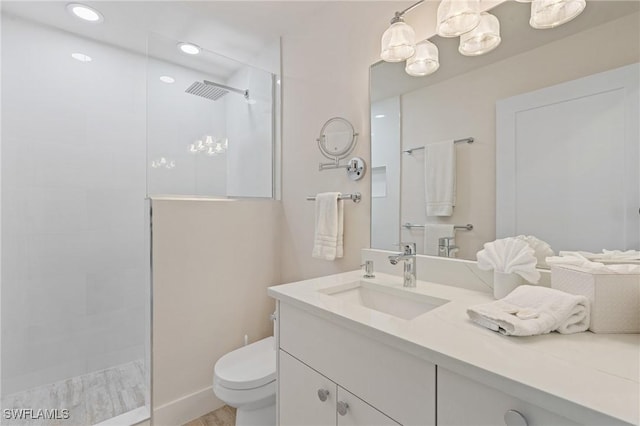 bathroom featuring toilet, recessed lighting, walk in shower, and vanity