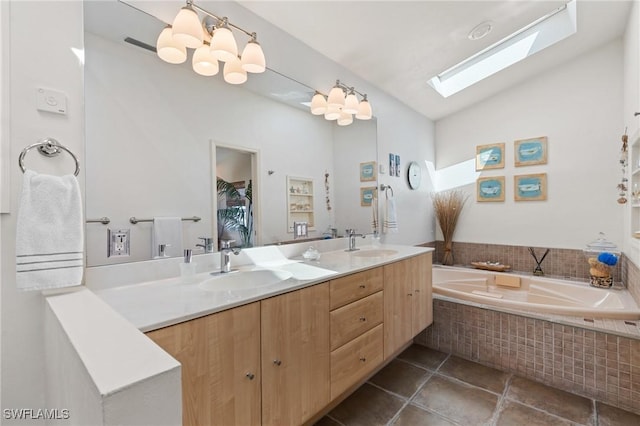 full bath featuring double vanity, vaulted ceiling with skylight, tiled tub, and a sink