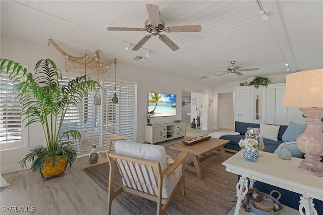 interior space with visible vents, vaulted ceiling, track lighting, and wood finished floors