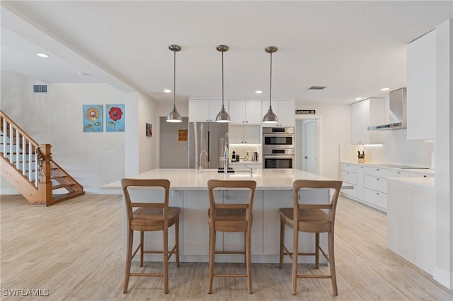 kitchen with stainless steel appliances, a spacious island, light countertops, hanging light fixtures, and white cabinetry