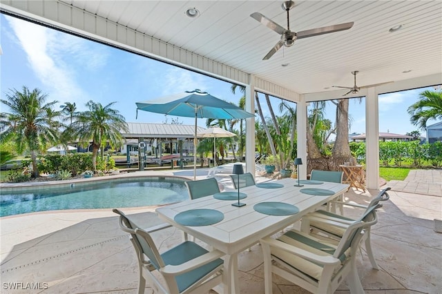 view of patio with ceiling fan, outdoor dining space, and an outdoor pool