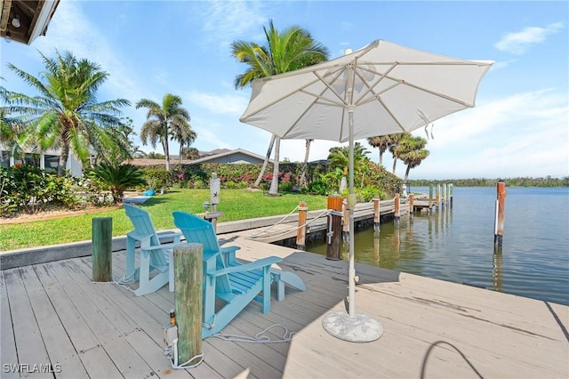 view of dock featuring a water view and a yard