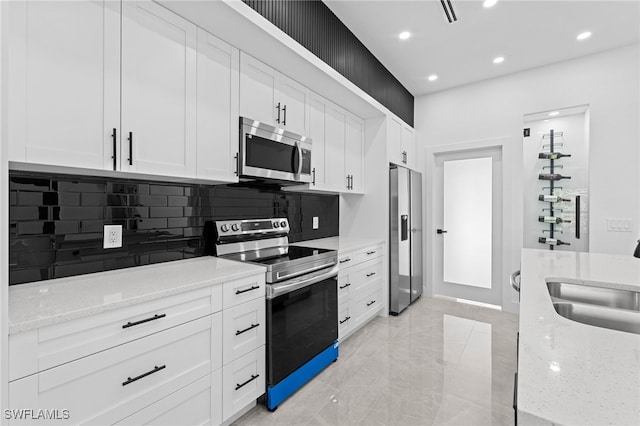 kitchen with stainless steel appliances, sink, and white cabinets