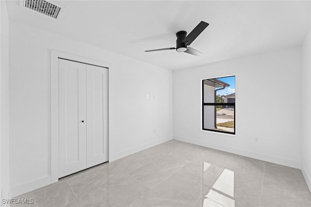 unfurnished bedroom featuring ceiling fan and a closet