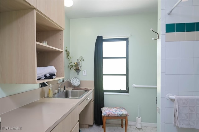 clothes washing area featuring plenty of natural light and sink