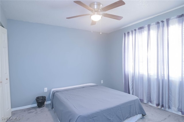 bedroom with ceiling fan and light carpet