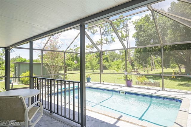 view of pool featuring a patio, glass enclosure, and a lawn