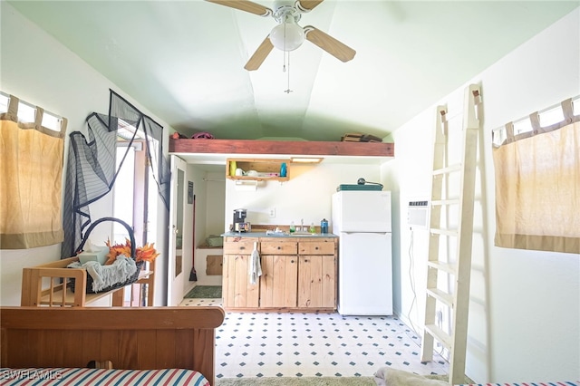 kitchen featuring lofted ceiling, sink, ceiling fan, white refrigerator, and light brown cabinets