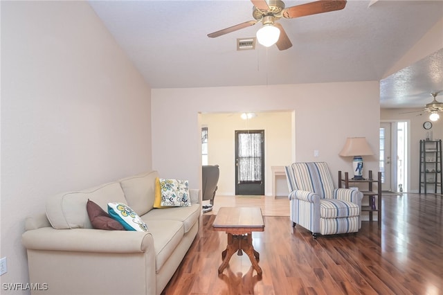 living room featuring vaulted ceiling, ceiling fan, hardwood / wood-style floors, and a textured ceiling