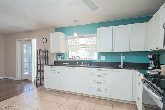 kitchen featuring pendant lighting, white cabinetry, sink, light tile patterned floors, and ceiling fan