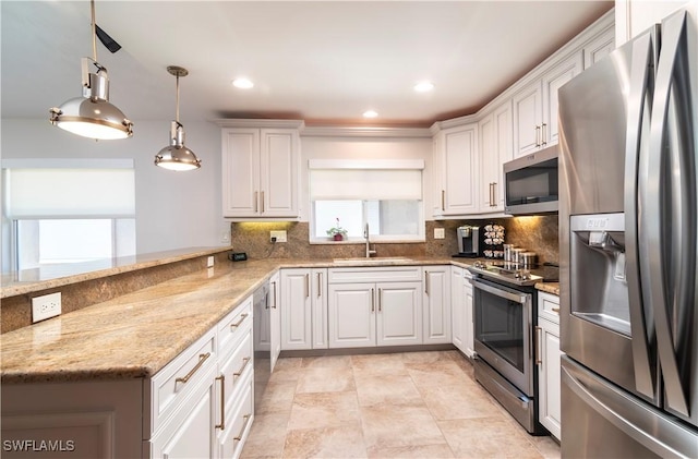 kitchen featuring sink, kitchen peninsula, white cabinets, and appliances with stainless steel finishes