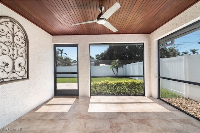 unfurnished sunroom with ceiling fan and wood ceiling