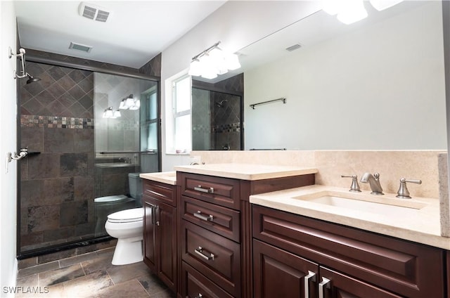 bathroom with a shower with door, vanity, and toilet