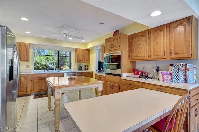 kitchen with appliances with stainless steel finishes, sink, light tile patterned floors, and ceiling fan