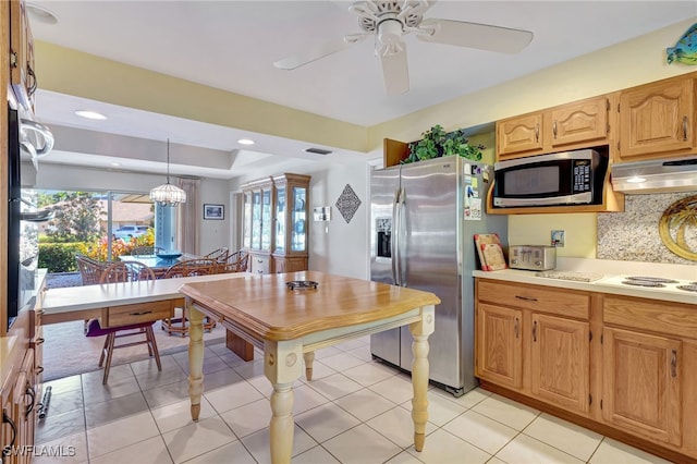 kitchen featuring ventilation hood, hanging light fixtures, light tile patterned floors, appliances with stainless steel finishes, and decorative backsplash