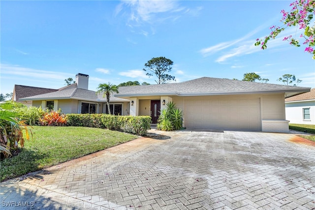 ranch-style home featuring a garage and a front lawn