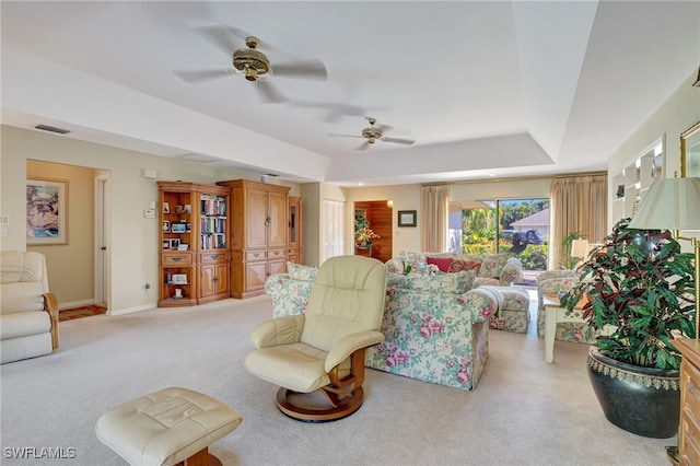 carpeted living room with a tray ceiling