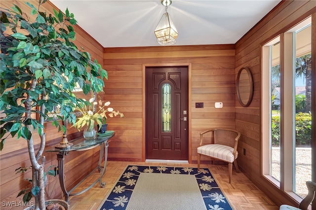 foyer entrance featuring light parquet flooring and wood walls