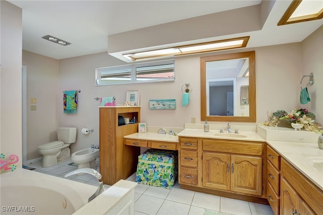 bathroom featuring a bidet, a washtub, vanity, tile patterned floors, and toilet