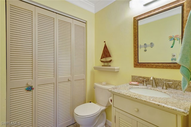 bathroom featuring vanity, crown molding, and toilet