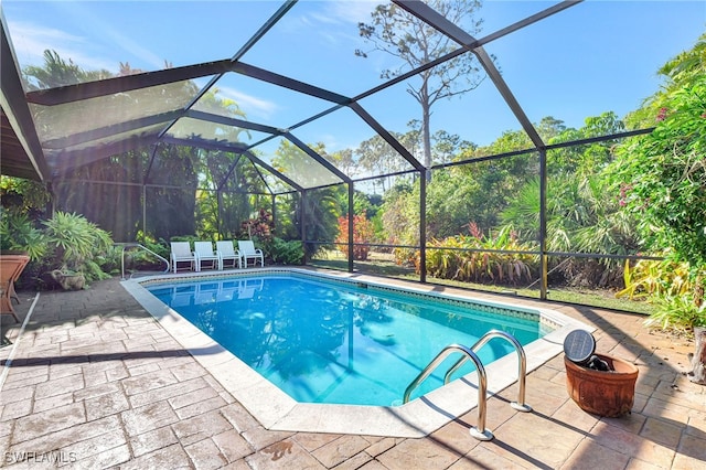 view of swimming pool featuring a lanai and a patio area