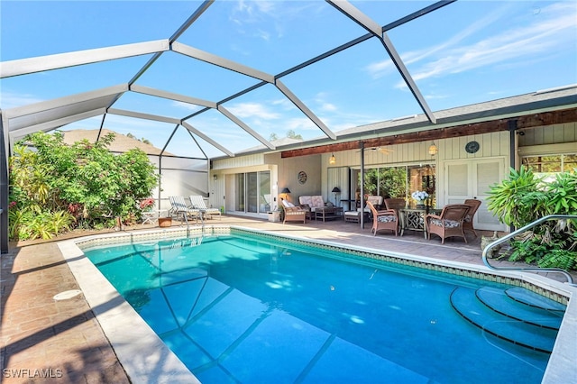 view of pool with ceiling fan, an outdoor living space, a patio, and glass enclosure