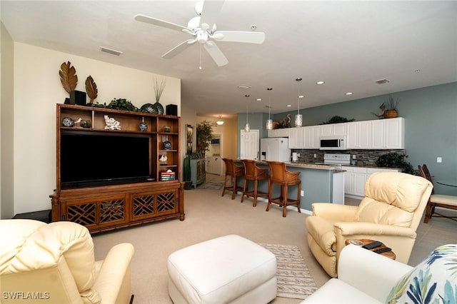 carpeted living room with ceiling fan