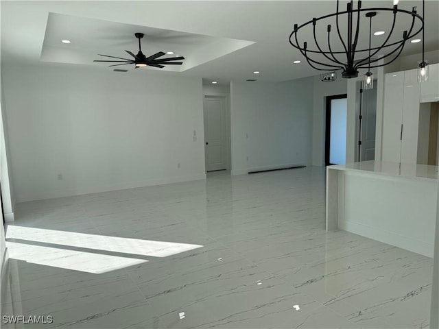 empty room with a raised ceiling and ceiling fan