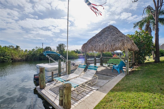 dock area with a water view, a gazebo, and a lawn