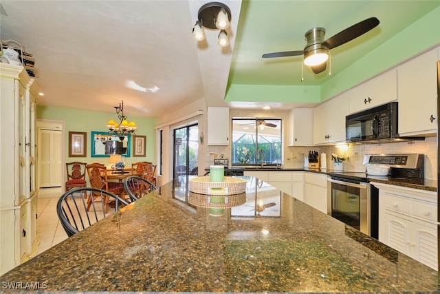 kitchen with stainless steel electric stove, white cabinetry, sink, backsplash, and light tile patterned floors