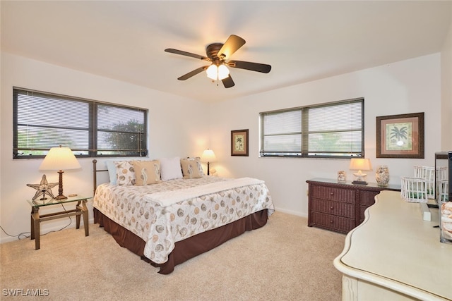 carpeted bedroom featuring multiple windows and ceiling fan