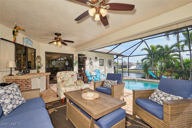 view of patio with a lanai, ceiling fan, a water view, an outdoor living space, and exterior bar